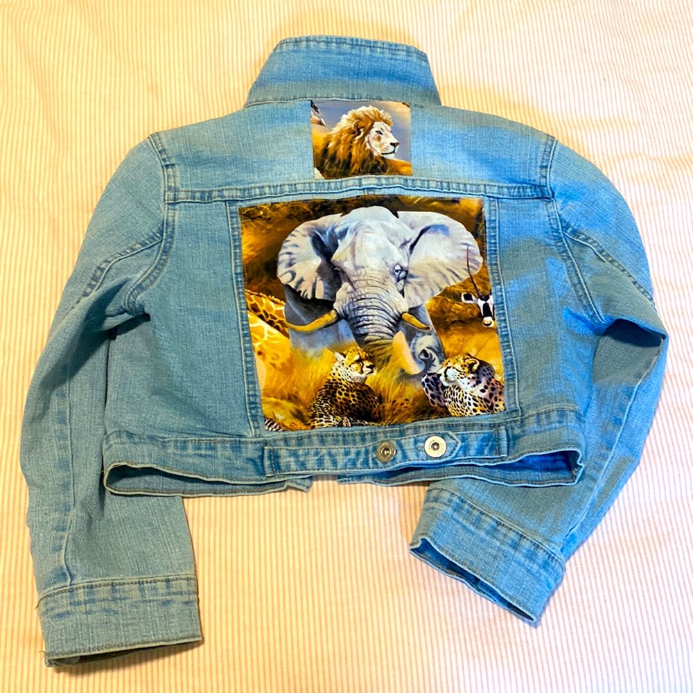 Kids jean jacket in size 6-7 with animal themed appliqués.